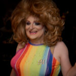 Color photograph of arkansas drag queen miss gay arkansas america 1992 missy klein in rainbow striped summer dress