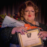 Color photograph taken by Chris Attig Blue Bus Photos showing Arkansas Drag Queen Gigi Galore winning her crown in the Miss Gay Central Arkansas America Drag Pageant 2023 in Conway, Arkansas.