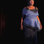 Color photograph of Arkansas drag queen jazmyn turrelle foster performing in gown at miss gay central arkansas america drag pageant.