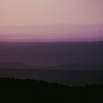 atmospheric perspective of the cascading mountain ranges in various shades of purple and pink and orange visible from the north western slope of Mt. Nebo in Dardanelle Arkansas taken by Little Rock Arkansas Queer Photographer Gynger