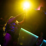 color image of of Little Rock Arkansas Drag Queen Moan A Lott performing at Diamonds and Pearls at Club Sway while dancing with her hands full of her tip money over her head