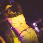 color image of Little Rock Arkansas Drag go go dancer performing at intermission of Diamonds and Pearls at Club Sway in a yellow skirt and top