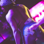 color image of Little Rock Arkansas Drag go go dancer Ed Gates performing at intermission of Diamonds and Pearls at Club Sway in a yellow skirt and top