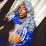 color image of Little Rock Arkansas Drag Queen Devi Diamond in silver gray hair and a blue top and dress at Diamonds and Pearls at Club Sway