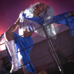 color image of Little Rock Arkansas Drag Queen Devi Diamond in silver gray hair and a blue top and dress at Diamonds and Pearls at Club Sway