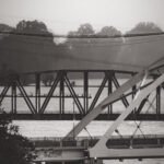 photo of the broadway bridge, and behind it the Baring Crossing RR Bridge, as they cross the Arkansas River in downtown little rock taken by Gynger a queer photographer from Little Rock Arkansas