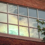 Window in a studio apartment in the Tuffnet Area of Downtown Little Rock reflects the colors of the morning sunrise, as seen by Little Rock Arkansas Trans woman and queer photographer Gynger St Claire